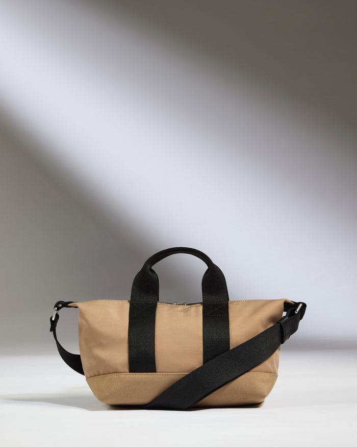 a tan bag with black straps