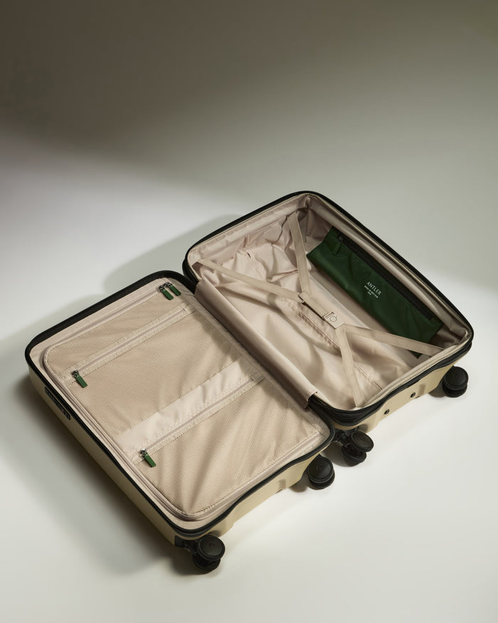 a suitcase with wheels and a green bag