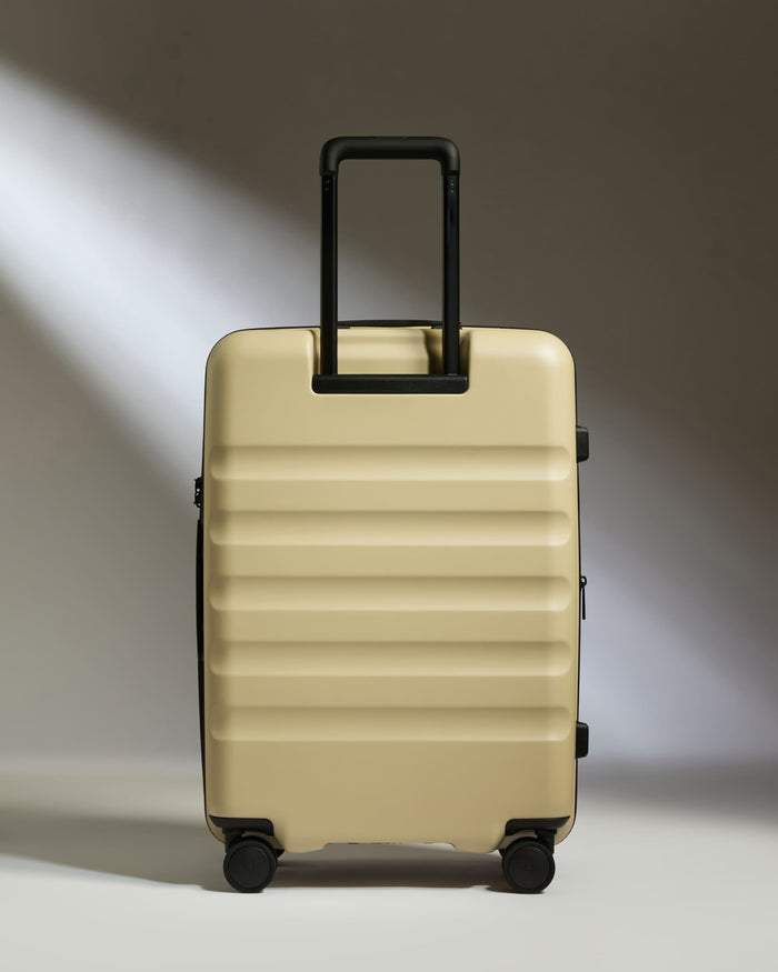 a tan suitcase with black handle